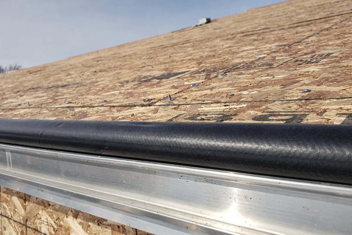 A new drip edge and gutter along the eave of a Michigan roof